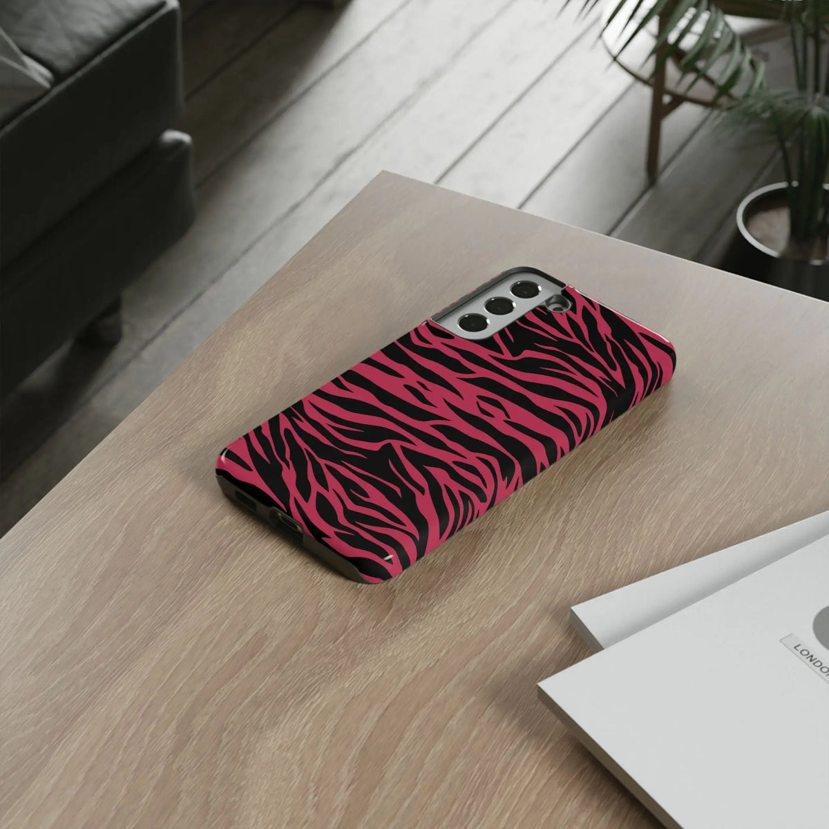 Back side of a magenta wild tiger pattern print phone case with vibrant pink and black zebra stripes and glossy finish