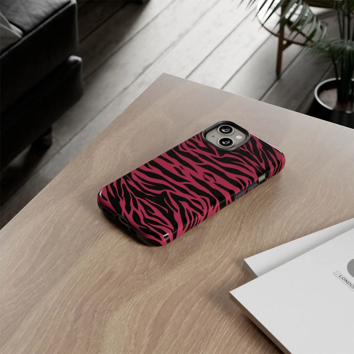 Back side of a sleek protective phone case with vibrant magenta wild tiger pattern print in pink and black zebra stripes